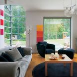 Na ścianach wiszą kolorowe obrazy. Dom otwarty na las