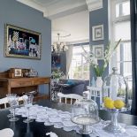 Na ścianie sztuka współczesna, na stole koronkowy bieżnik w stylu vintage.