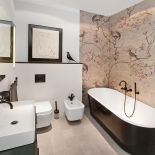 Na ścianie wodoodporna tapeta Wall Deco z nawiązującym do chińskich jedwabi motywem kwiatów i ptaków.