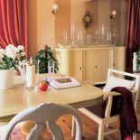 Na szafce stoi szklana kolekcja. Przytulne wnętrze domu w stylu rystykalnym