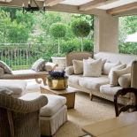 Na werandzie stoją plecione wiklinowe meble.