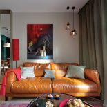 Nad kanapa plakat grupy artystycznej Present Continuous, surrealistyczna martwa natura.