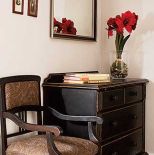 Nad komodą wisi lustro. Dyskretny urok czerwieni