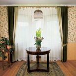 Nad okrągłym stolikiem wisi lampa. Sypialnia po angielsku