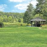 Nad rzekę spływa kaskada liliowców i irysów, która przechodzi w kwietną łąkę.