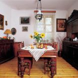 Nad stołem wisi zdobiona lampa. Nowoczesność ukryta