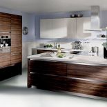 Największą ozdobą tej kuchni jest drewno z pasiastymi słojami. Zastosowany system bezuchwytowy oraz listwy są