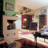 Narożny kominek w salonie. Wnętrza urządzone z tradycją