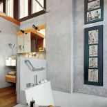 Nawet w łazience na ścianie wisi sztuka: do betonowych ścian pasują grafiki oprawione w antyramę.
