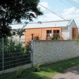 Neutralny budynek wkomponowany w ogród.