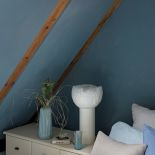 niebieska sypialnia z drewnem na poddaszu