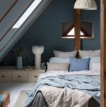 niebieska sypialnia z drewnem na poddaszu