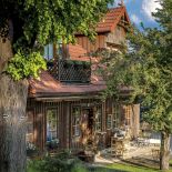 Niskie drewniane domy z charakterystycznie ściętym i dachami otaczają pochyły rynek. To dzięki nim w