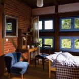 Niebieskie ramy okienne kontrastują z ceglanym murem.