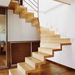 Nowoczesne zawieszone nad ziemią schody skonstruowane z litego drewna jesionowego (samej bieli). Balustrada ze stali