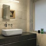 Bardzo dekoracyjna półka wpuszczona w ścianę, z drewnianą ramą, szklanym panelem i przesuwanym lustrem.