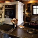 Obok blatu ceramicznego znajduje się kuchnia węglowa.