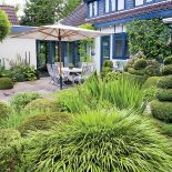 Obok domu taras płynnie wchodzący do ogrodu.