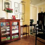 Obok wypełnionej książkami witryny stoi konsola.