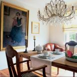 Obraz w złoconej ramie komponuje się zkryształowym żyrandolem.