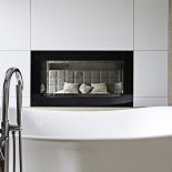 Obustronnie przeszklony biokominek umożliwia kontakt wzrokowy między sypialnią a łazienką.