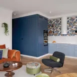 pomarańczowy narożnik w salonie z kuchnią