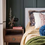 ciemny kolor ścian w sypialni i kontrastowe poduszki