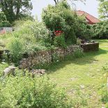 Ogród dzielą kamienne murki. Ogród jak sprzed lat