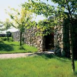 Ogród od drogi odgradza mur z kamienia. Widoku na łąki i pola i las nic nie zasłania.