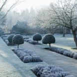 Wejście do tajemniczego, zimowego ogrodu prowadzi przez półokrągłą furtę