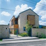 Ogrodzenie także zbudowano z wapienia, aby dobrze komponowało się z elewacją domu.