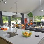 Ogromna wyspa z wygodnym corianowym blatem to najważniejsze miejsce w domu