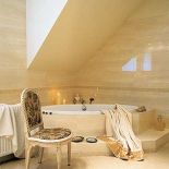 Okien nie mogło zabraknąć także w łazience. W kremowych gresach i marmurowych dekorach o świcie przegląda się słońce.