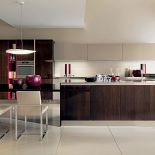 Orzechowa wyspa na pierwszym planie to B-50 (Berloni). Do wyboru 50 kolorów i przeróżne wykończenia. STUDIO ITALIA