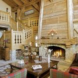 Otwarty, wysoki kominek z kamienia i świerkowego drewna, zaprojektowany przez architekta Nicolasa Perrin, ogrzewa cały