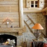 Otwarty, wysoki kominek z kamienia i świerkowego drewna, zaprojektowany przez architekta Nicolasa Perrin, ogrzewa cały