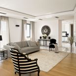 Pani domu powiesiła lniane zasłony, wstawiła kanapy i położyła dywan w ekologicznych kolorach.