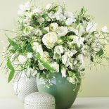 Pękaty pastelowy wazon i bukiet białych kwiatów - niezastąpiona klasyka gatunku.