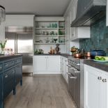 Piekna kolorystyka: chłodna śmietanowa biel na ciągu meblowym oraz ciemny błękit na wyspie.