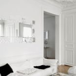 Piękne architektoniczne detale starej kamienicy i nowoczesna kanapa Le Corbusiera. Wszystko, oczywiście, białe.