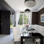 Pikowane krzesła z Almi Deco, nad stołem lampy Sky Garden firmy Flos.