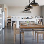 Podłoga, zlew i wyspa kuchenna zostały zrobione z woskowanego betonu.. Stół przyjechał z Bali, krzesła