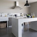 Podłoga, zlew i wyspa kuchenna zostały zrobione z woskowanego betonu.. Stół przyjechał z Bali, krzesła