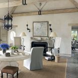 Podłogę w salonie wyłożono marokańskimi płytkami z terakoty, na nich dywan z sizalu. Przy kominku wysokie fotele w stylu