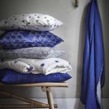 Leciutkie rattanowe fotele i ławki, kosze uplecione z morskich traw, lniana pościel w kolorze indygo,