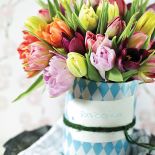 Pomysł na dekorację z tulipanów. Bukiet stoi w wazonie, który jest zrobiony ze sterej puszki.