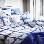 Leciutkie rattanowe fotele i ławki, kosze uplecione z morskich traw, lniana pościel w kolorze indygo,