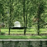 Pośrodku ogrodu nowoczesna fontanna z kulą z akrylu.