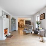 Pośrodku salonu stoi kominek z ceramicznym gzymsem.