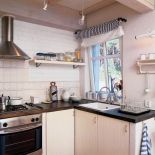 Prosta jasna kuchnia z subtelnymi elementami dekoracyjnymi.